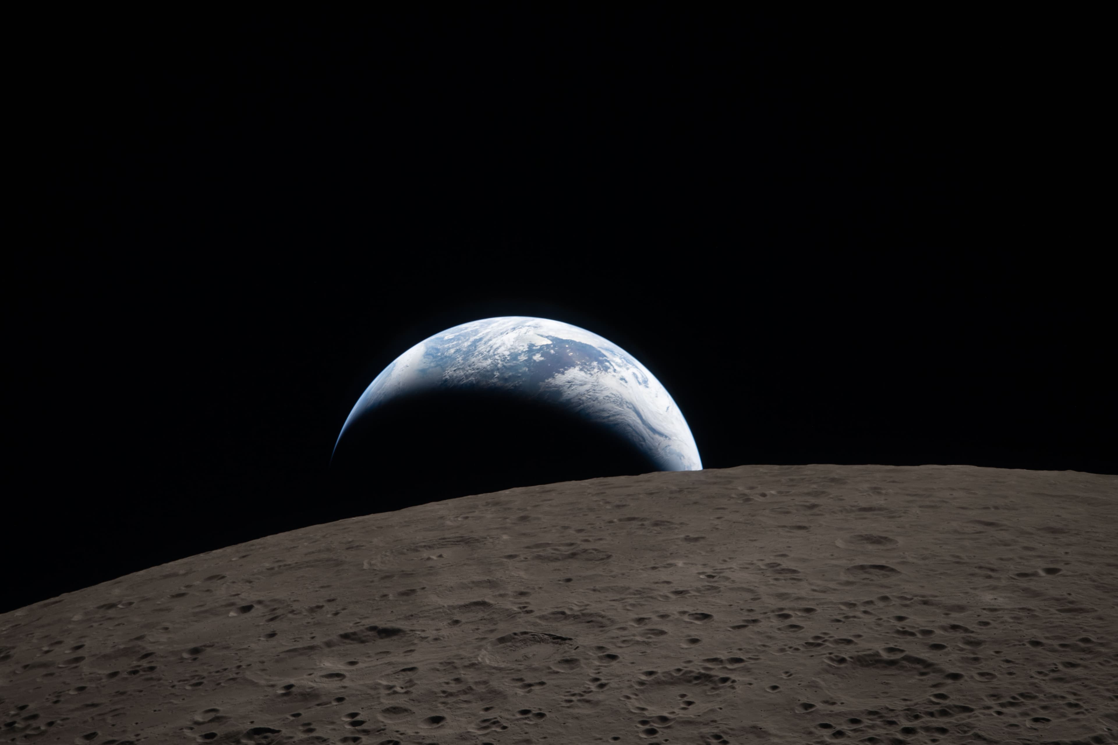 Earth rising above a dark horizon